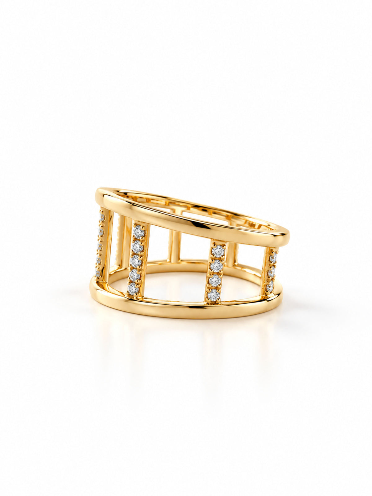 A gold openwork ring with vertical bars and small clear gemstone accents, photographed on a clean white background.