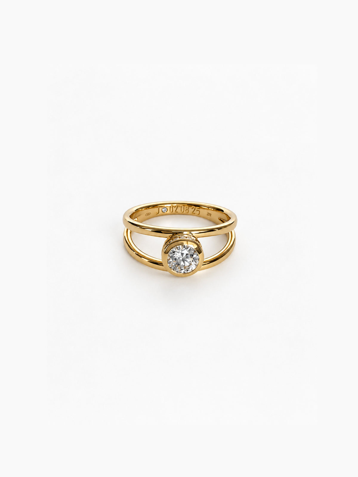 A gold ring with a single round clear gemstone in a prong setting, shown on a clean white background. The inner band is engraved with the brand name 'DROPS'.